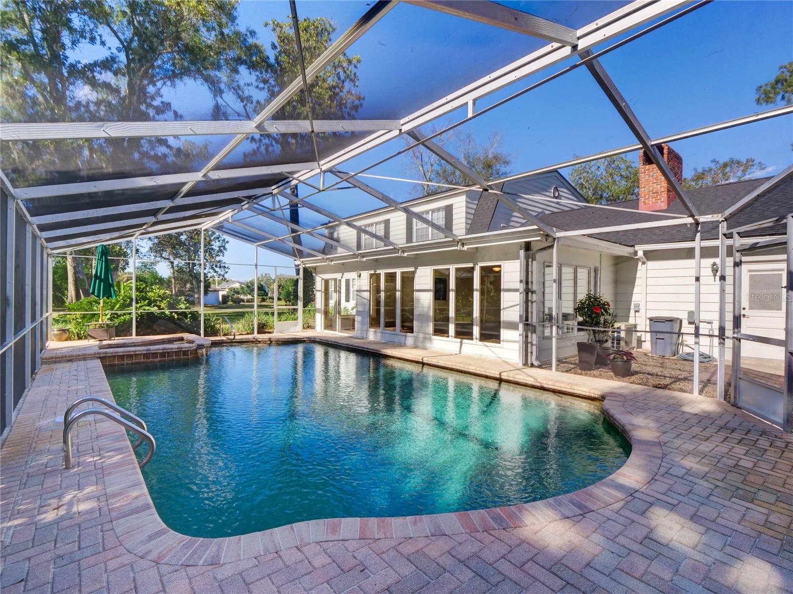 pool in enclosed patio off back of white painted home